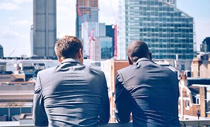 Two men in suits against the backdrop of the city